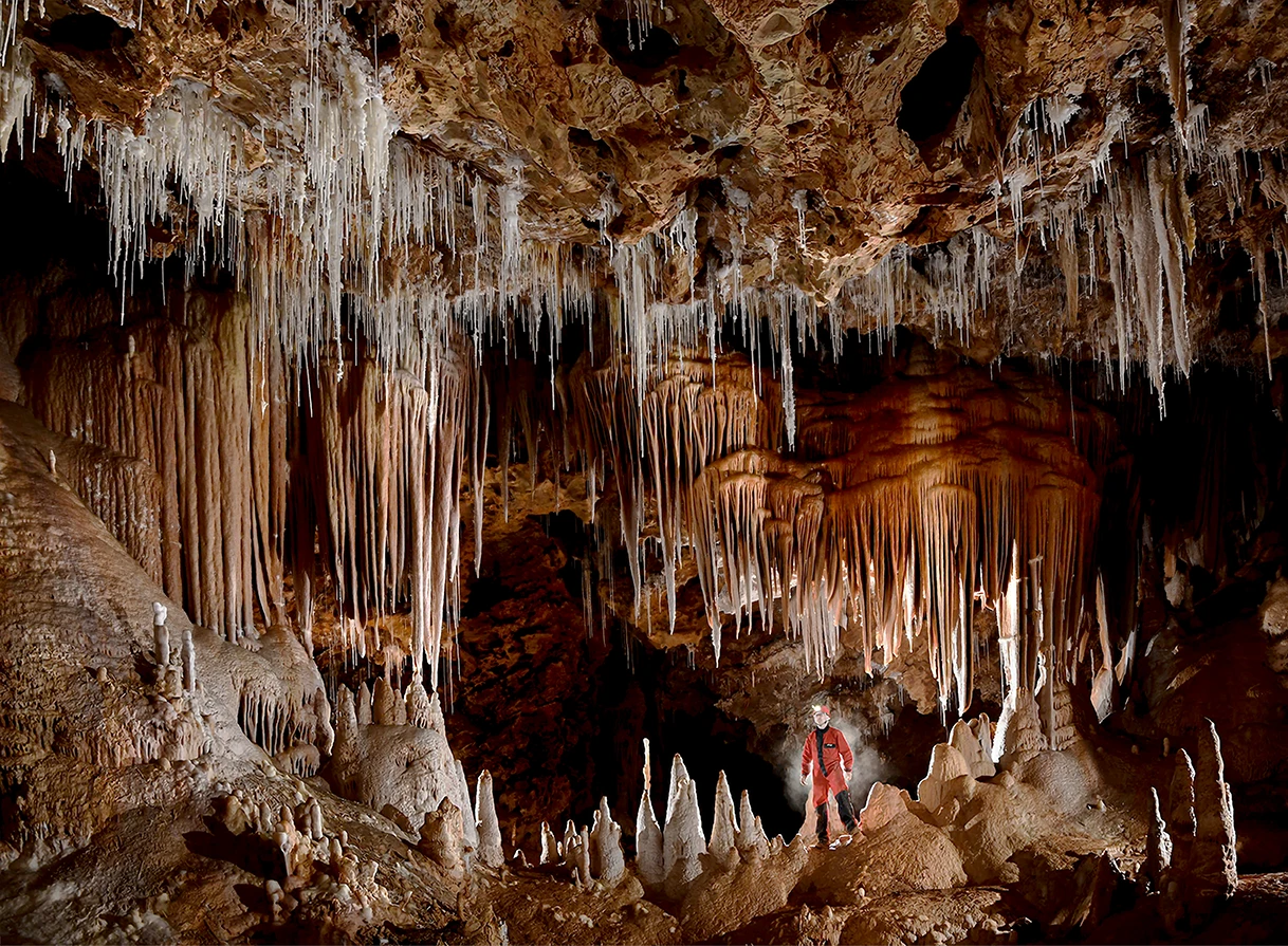 Photo de la mâchoire dans la grotte de Clamouse avec spéléologue et contre jour